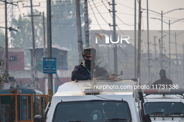 An Indian security personnel stands alert atop an armored vehicle during a gun battle between suspected militants and security forces in Sri...