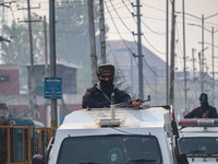 An Indian security personnel stands alert atop an armored vehicle during a gun battle between suspected militants and security forces in Sri...