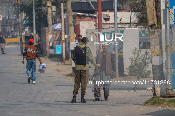 An Indian policeman stops a civilian near the site of a gunbattle between suspected militants and security forces in Srinagar, Jammu and Kas...