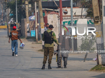 An Indian policeman stops a civilian near the site of a gunbattle between suspected militants and security forces in Srinagar, Jammu and Kas...