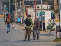 An Indian policeman stops a civilian near the site of a gunbattle between suspected militants and security forces in Srinagar, Jammu and Kas...