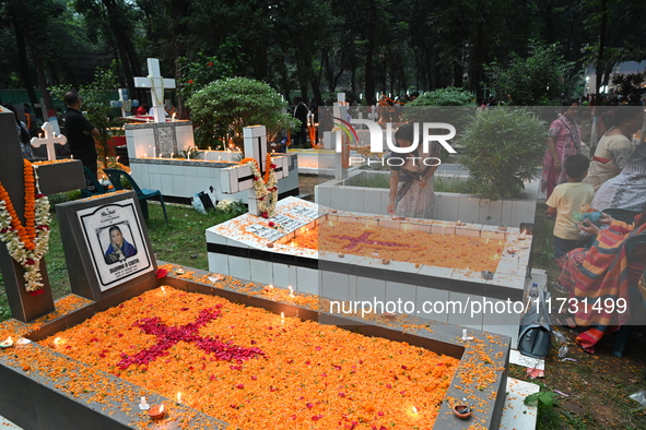 Christian devotees light candles on the graves of relatives during the celebrations of All Souls Day in a cemetery at Wari Cemetery of Holy...