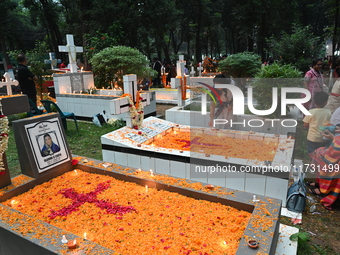 Christian devotees light candles on the graves of relatives during the celebrations of All Souls Day in a cemetery at Wari Cemetery of Holy...