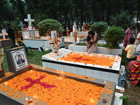 Christian devotees light candles on the graves of relatives during the celebrations of All Souls Day in a cemetery at Wari Cemetery of Holy...