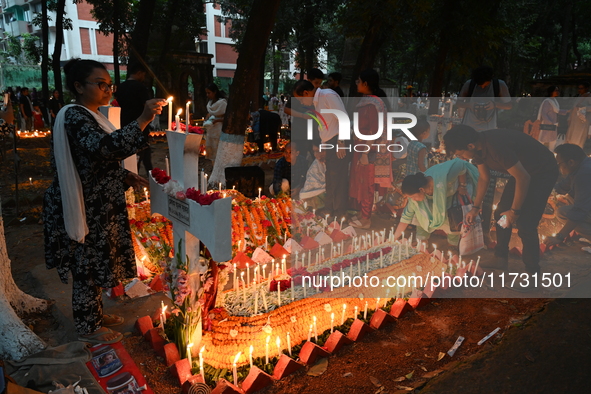 Christian devotees light candles on the graves of relatives during the celebrations of All Souls Day in a cemetery at Wari Cemetery of Holy...