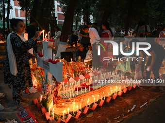 Christian devotees light candles on the graves of relatives during the celebrations of All Souls Day in a cemetery at Wari Cemetery of Holy...