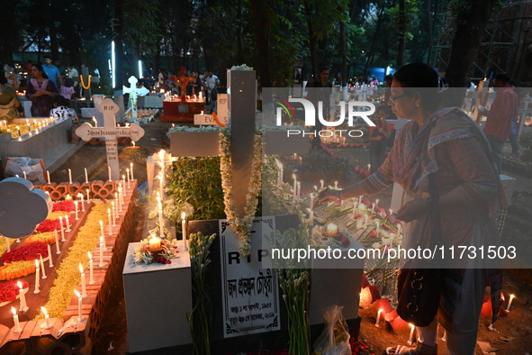 Christian devotees light candles on the graves of relatives during the celebrations of All Souls Day in a cemetery at Wari Cemetery of Holy...