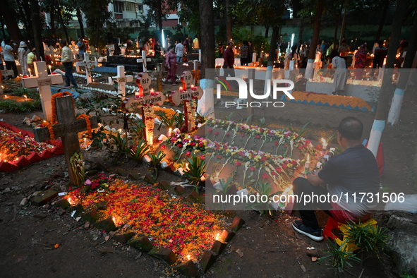 Christian devotees light candles on the graves of relatives during the celebrations of All Souls Day in a cemetery at Wari Cemetery of Holy...