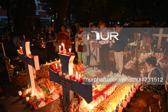 Christian devotees light candles on the graves of relatives during the celebrations of All Souls Day in a cemetery at Wari Cemetery of Holy...