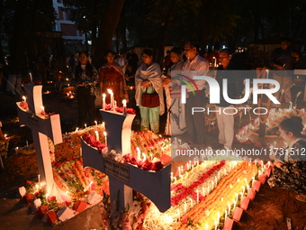 Christian devotees light candles on the graves of relatives during the celebrations of All Souls Day in a cemetery at Wari Cemetery of Holy...