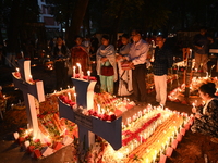 Christian devotees light candles on the graves of relatives during the celebrations of All Souls Day in a cemetery at Wari Cemetery of Holy...