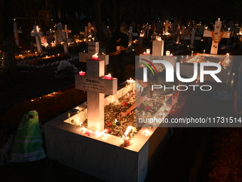 Christian devotees light candles on the graves of relatives during the celebrations of All Souls Day in a cemetery at Wari Cemetery of Holy...