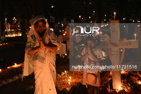 Christian devotees light candles on the graves of relatives during the celebrations of All Souls Day in a cemetery at Wari Cemetery of Holy...