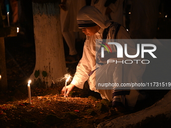 Christian devotees light candles on the graves of relatives during the celebrations of All Souls Day in a cemetery at Wari Cemetery of Holy...