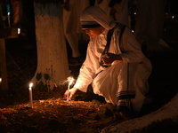 Christian devotees light candles on the graves of relatives during the celebrations of All Souls Day in a cemetery at Wari Cemetery of Holy...