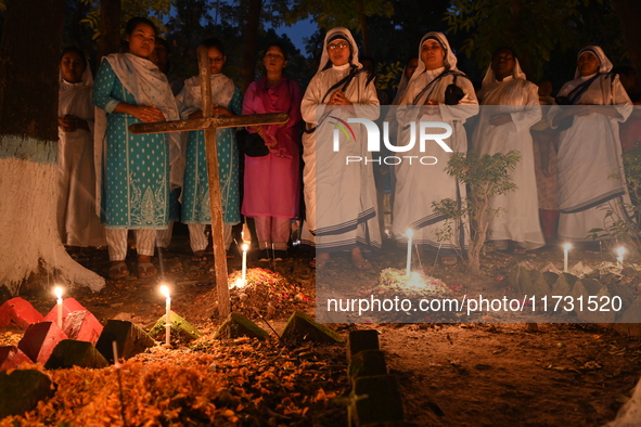 Christian devotees light candles on the graves of relatives during the celebrations of All Souls Day in a cemetery at Wari Cemetery of Holy...