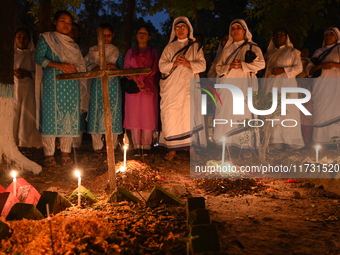 Christian devotees light candles on the graves of relatives during the celebrations of All Souls Day in a cemetery at Wari Cemetery of Holy...