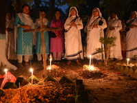 Christian devotees light candles on the graves of relatives during the celebrations of All Souls Day in a cemetery at Wari Cemetery of Holy...