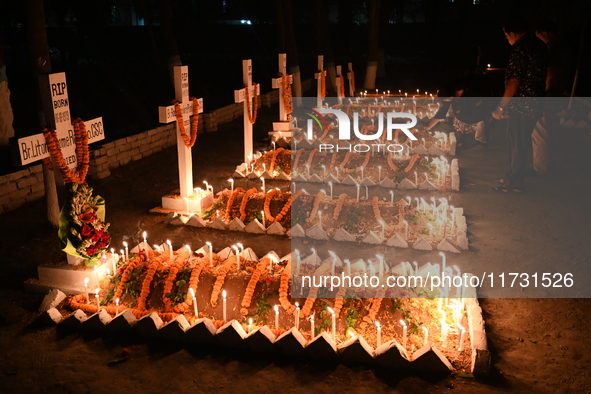 Christian devotees light candles on the graves of relatives during the celebrations of All Souls Day in a cemetery at Wari Cemetery of Holy...