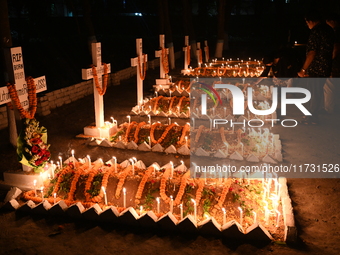 Christian devotees light candles on the graves of relatives during the celebrations of All Souls Day in a cemetery at Wari Cemetery of Holy...