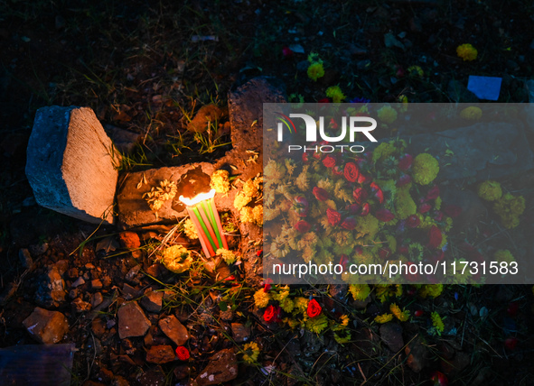 A grave is adorned with flowers and candles during All Souls Day at a Christian cemetery in Hyderabad, on November 2, 2024. 