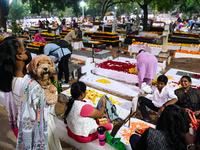 A family with a pet dog prays next to the grave of departed ones to commemorate All Souls Day at a cemetery in Hyderabad, on November 2, 202...