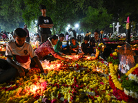 Family and friends light candles at the graves of departed ones to commemorate All Souls Day at a cemetery in Hyderabad, on November 2, 2024...