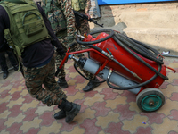 Indian paramilitary troopers carry a flamethrower as they move towards an encounter site in Srinagar, Indian Administered Kashmir, on Novemb...