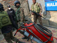 Indian paramilitary troopers carry a flamethrower as they move towards an encounter site in Srinagar, Indian Administered Kashmir, on Novemb...