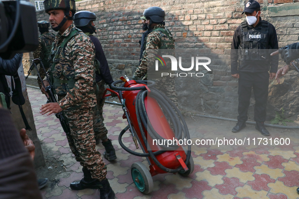 Indian paramilitary troopers carry a flamethrower as they move towards an encounter site in Srinagar, Indian Administered Kashmir, on Novemb...