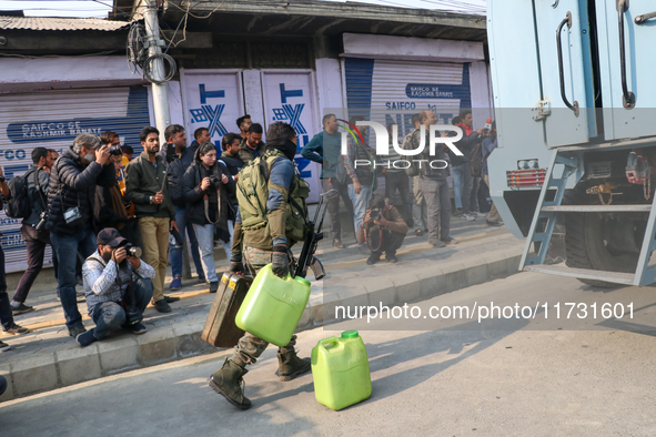 Indian paramilitary troopers carry fuel as they move towards an encounter site in Srinagar, Indian Administered Kashmir, on November 2, 2024...