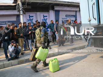 Indian paramilitary troopers carry fuel as they move towards an encounter site in Srinagar, Indian Administered Kashmir, on November 2, 2024...