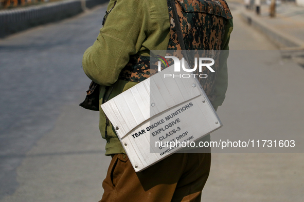 An Indian policeman carries tear gas munitions near the encounter site in Srinagar, Indian Administered Kashmir, on November 2, 2024. Three...