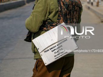 An Indian policeman carries tear gas munitions near the encounter site in Srinagar, Indian Administered Kashmir, on November 2, 2024. Three...