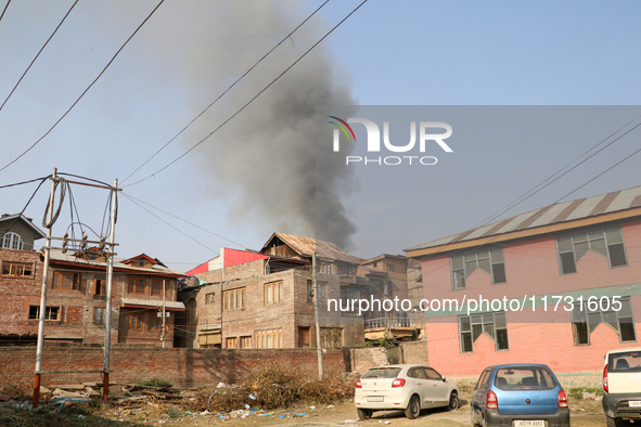 Smoke billows from a residential house where a gunbattle between Indian forces and militants ensues in Srinagar, Indian-administered Kashmir...