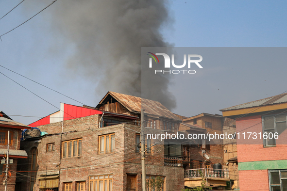 Smoke billows from a residential house where a gunbattle between Indian forces and militants ensues in Srinagar, Indian-administered Kashmir...