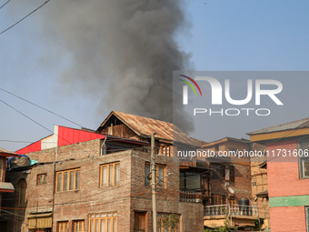 Smoke billows from a residential house where a gunbattle between Indian forces and militants ensues in Srinagar, Indian-administered Kashmir...