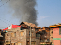 Smoke billows from a residential house where a gunbattle between Indian forces and militants ensues in Srinagar, Indian-administered Kashmir...