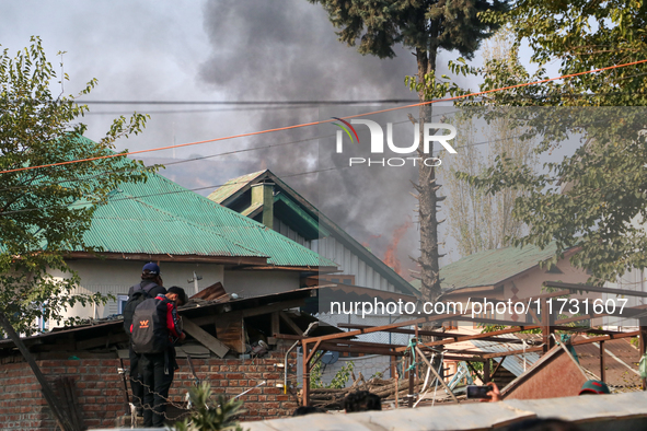 Smoke billows from a residential house where a gunbattle between Indian forces and militants ensues in Srinagar, Indian-administered Kashmir...