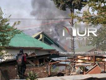 Smoke billows from a residential house where a gunbattle between Indian forces and militants ensues in Srinagar, Indian-administered Kashmir...