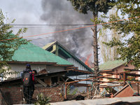 Smoke billows from a residential house where a gunbattle between Indian forces and militants ensues in Srinagar, Indian-administered Kashmir...