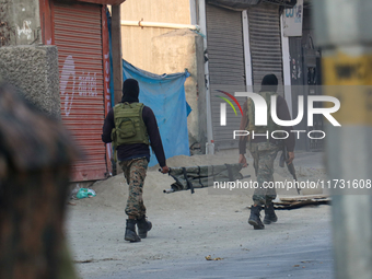 Indian paramilitary troopers carry a stretcher near the encounter site in Srinagar, Indian Administered Kashmir, on November 2, 2024. Three...