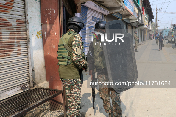 An Indian paramilitary trooper carries a bulletproof shield near the encounter site in Srinagar, Indian Administered Kashmir, on November 2,...