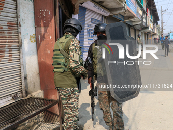 An Indian paramilitary trooper carries a bulletproof shield near the encounter site in Srinagar, Indian Administered Kashmir, on November 2,...