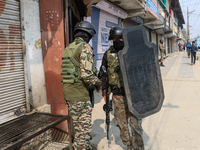 An Indian paramilitary trooper carries a bulletproof shield near the encounter site in Srinagar, Indian Administered Kashmir, on November 2,...