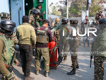 Indian paramilitary troopers carry a flamethrower as they move towards an encounter site in Srinagar, Indian Administered Kashmir, on Novemb...