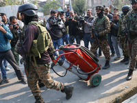 Indian paramilitary troopers carry a flamethrower as they move towards an encounter site in Srinagar, Indian Administered Kashmir, on Novemb...