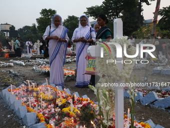 People light candles and lay flowers on the graves of their relatives at a cemetery during All Souls Day in Kolkata, India, on November 2, 2...