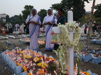 People light candles and lay flowers on the graves of their relatives at a cemetery during All Souls Day in Kolkata, India, on November 2, 2...