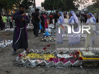 People light candles and lay flowers on the graves of their relatives at a cemetery during All Souls Day in Kolkata, India, on November 2, 2...